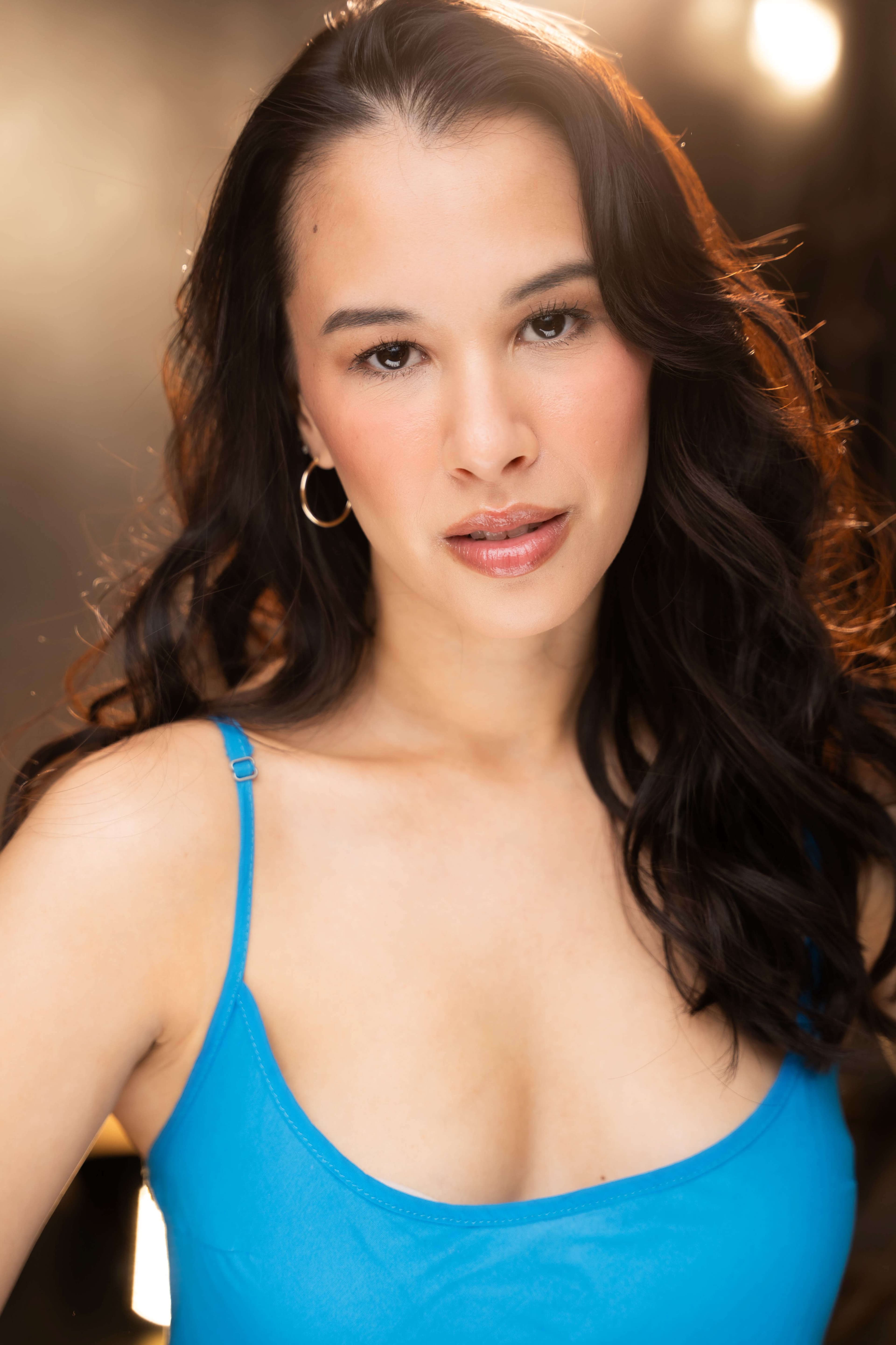 Bree Mignano headshot, natural expression in a blue tank top