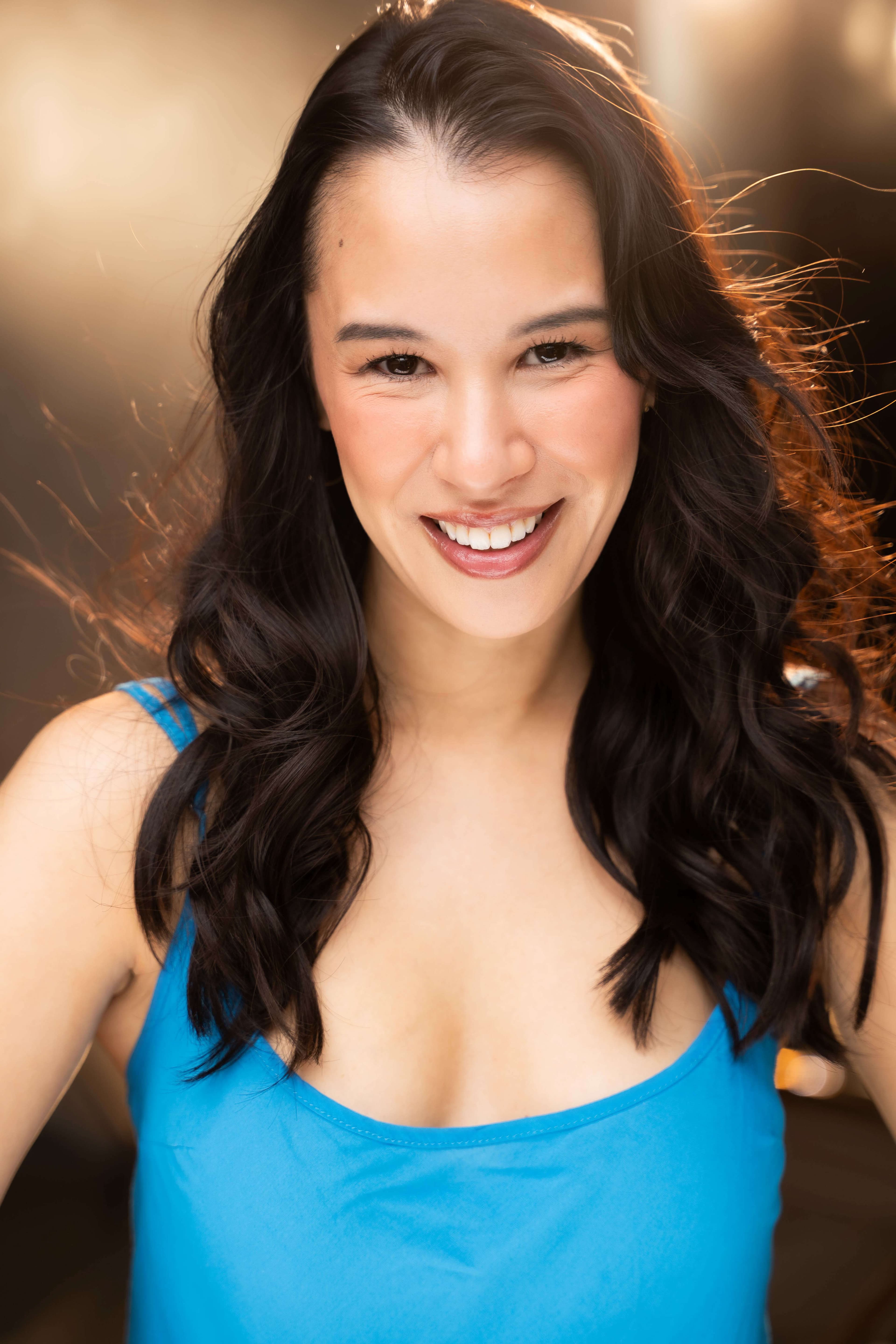 Bree Mignano smiling headshot in a blue tank top