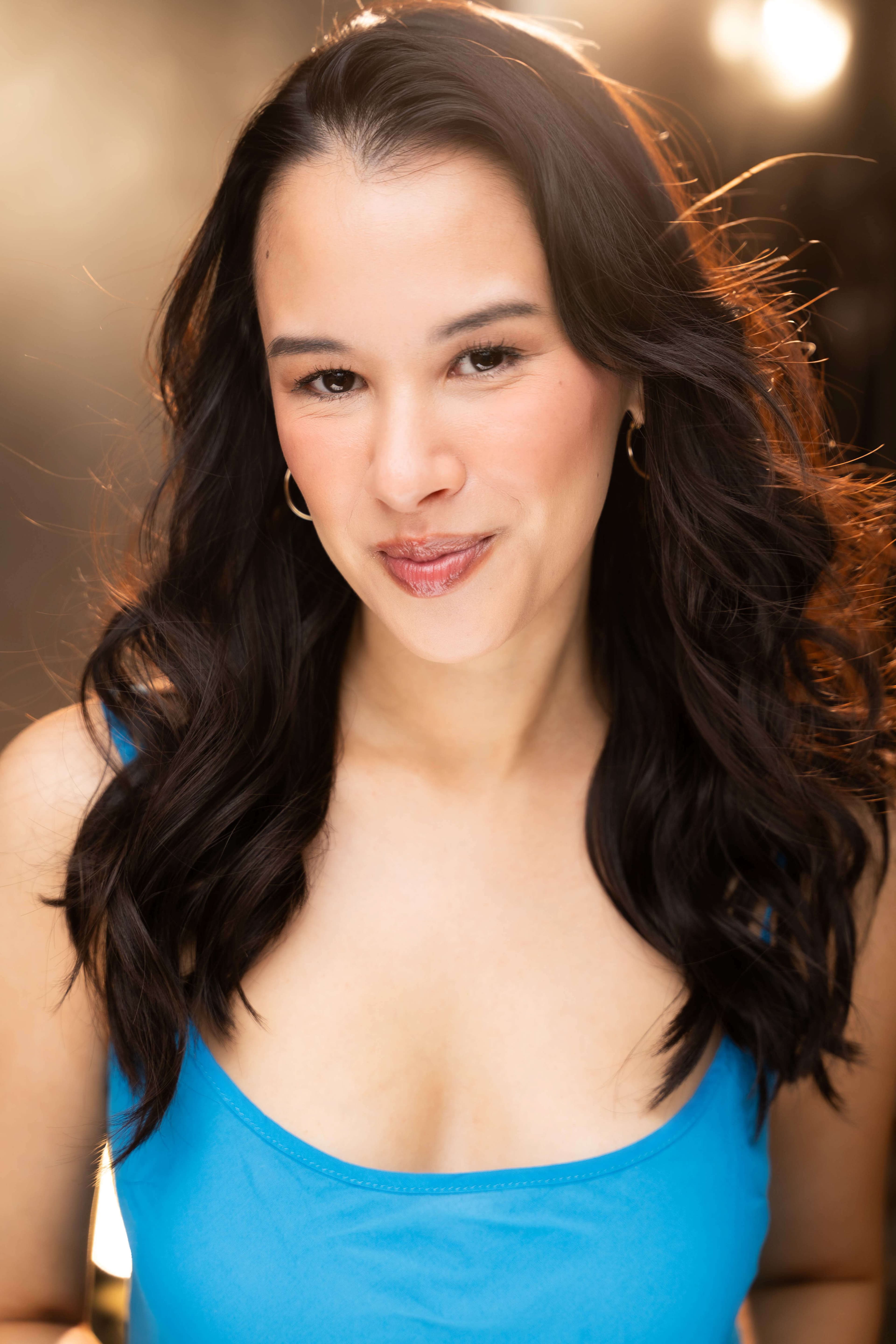 Bree Mignano headshot with a soft smile in a blue tank top